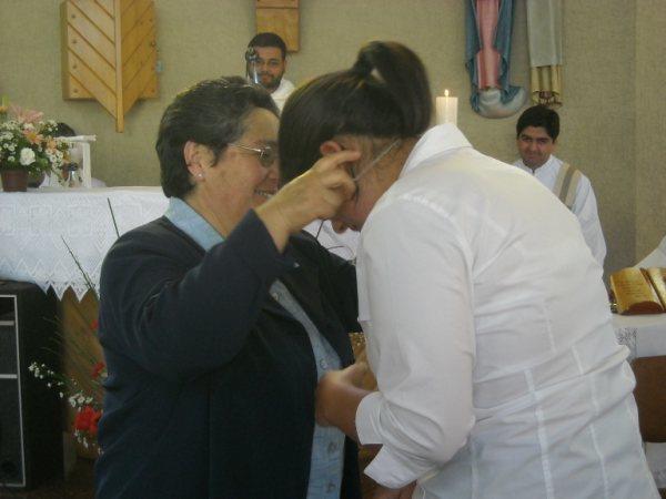 La hermana Gladys Sandoval impone la cruz de la Congregación a María Luisa.